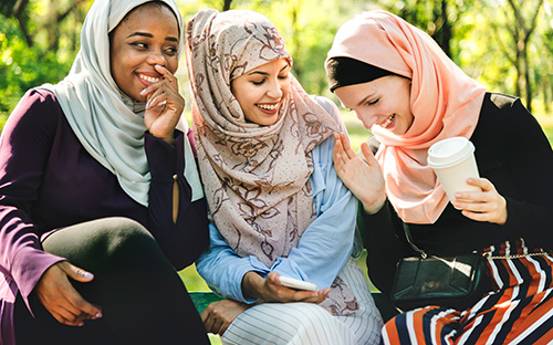 muslim women laughing having coffee